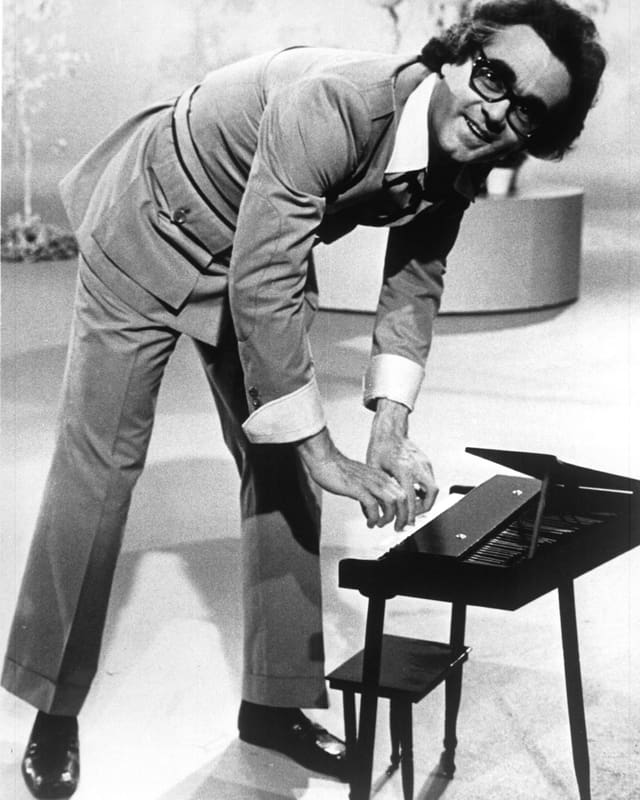Michel Legrand spielt auf einem kleinen Klavier. Michel Legrand spielt auf einem kleinen Klavier.