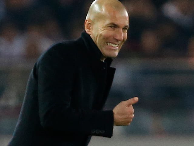 Zinedine Zidane grinst mit erhobenem Daumen.
