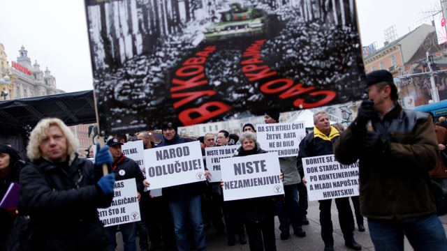 Demonstranten fordern auf einer Kundbegung in Zagreb (2013) ein Verbot des Kyrillischen auf Ortstafeln. Demonstranten fordern auf einer Kundbegung in Zagreb (2013) ein Verbot des Kyrillischen auf Ortstafeln.
