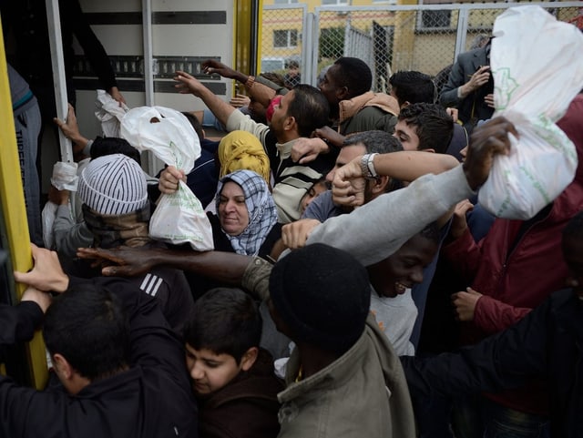 Syrische Flüchtlinge stehen an um an Essen zu kommen. Syrische Flüchtlinge stehen an um an Essen zu kommen.