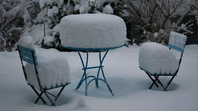 Gartentisch und Stühle mit Schnee bedeckt in einem Garten in Winterthur-Oberseen. Gartentisch und Stühle mit Schnee bedeckt in einem Garten in Winterthur-Oberseen.