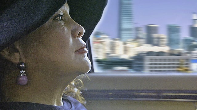 Chinesische Unternehmerin im Auto im Hintergrund eine Skyline Chinesische Unternehmerin im Auto im Hintergrund eine Skyline