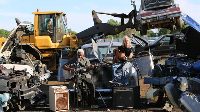 Zwei Musiker speilen vor einem Schrottplatz. Zwei Musiker speilen vor einem Schrottplatz.