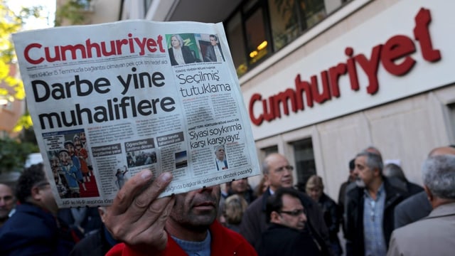Eine Person hält eine Zeitungsexemplar vor der Redaktion der «Cumhuriyet» in der Hand. Eine Person hält eine Zeitungsexemplar vor der Redaktion der «Cumhuriyet» in der Hand.