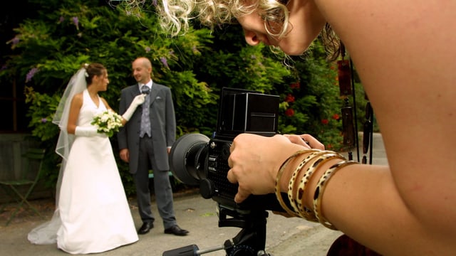 Eine Fotografin lichtet ein Hochzeitspaar ab Eine Fotografin lichtet ein Hochzeitspaar ab