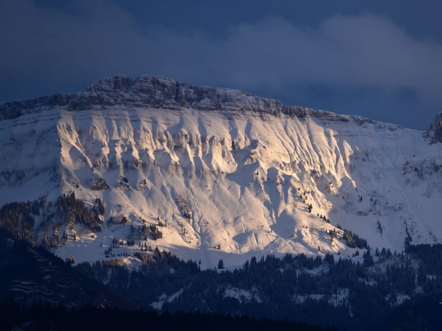 Weisser Berghang im zaghaften Sonnenlicht