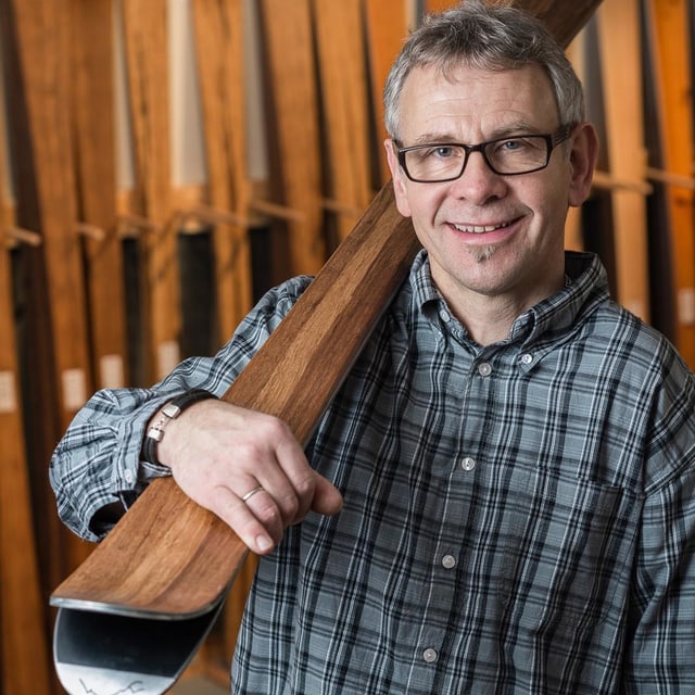 Mann trägt Holzski über der Schulter. Mann trägt Holzski über der Schulter.