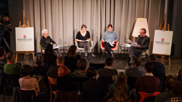 Drei Schauspielerinnen und ein Schauspieler sitzend auf der Bühne. Drei Schauspielerinnen und ein Schauspieler sitzend auf der Bühne.