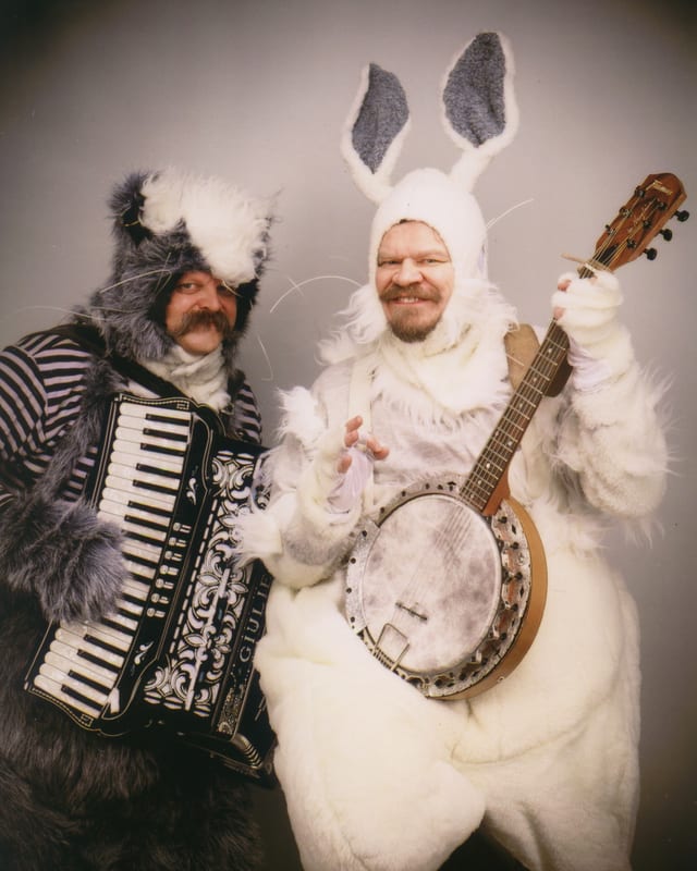 Zwei Männer in Tierkostümen mit Harmonika und Banjo. Zwei Männer in Tierkostümen mit Harmonika und Banjo.