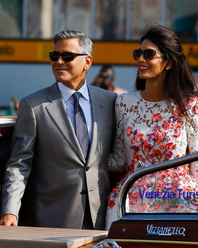 George Clooney und seine Frau posieren auf einem Boot. George Clooney und seine Frau posieren auf einem Boot.