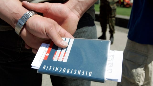 Soldat hält hinter seinem Rücken sein Dienstbüchlein. Soldat hält hinter seinem Rücken sein Dienstbüchlein.