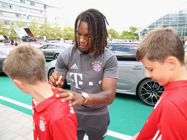 Renato Sanches gibt einem Jungen ein Autogramm aufs Shirt