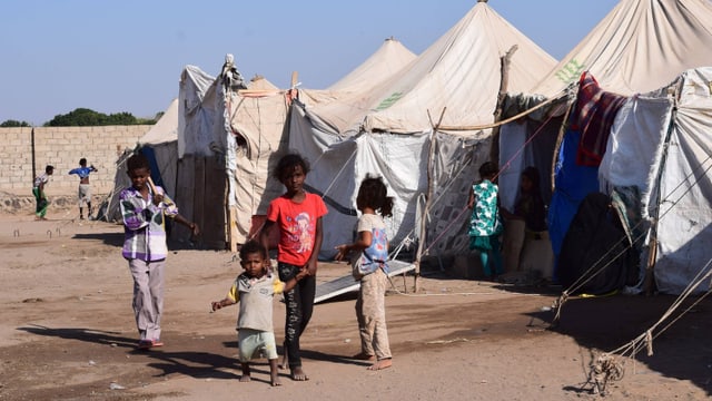 Kinder vor Zelten in einem Flüchtlingslager. Kinder vor Zelten in einem Flüchtlingslager.