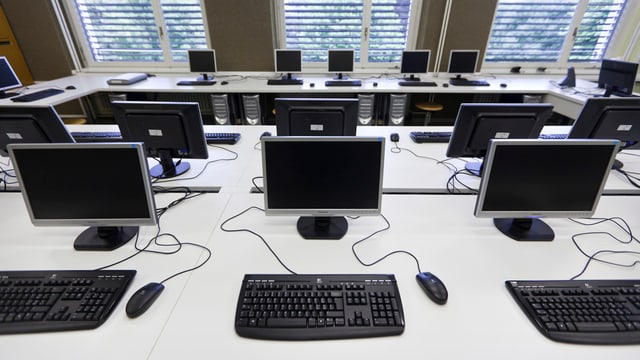 Viele Computer stehen auf Tischen in einem Schulzimmer. Viele Computer stehen auf Tischen in einem Schulzimmer.