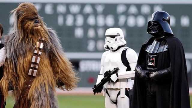 Pesronen in «Star Wars»-Kostümen in einem Stadion. Pesronen in «Star Wars»-Kostümen in einem Stadion.