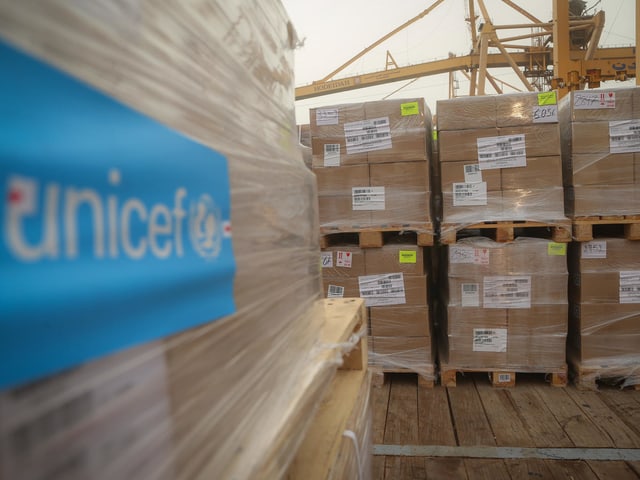 Palletten mit Kartons auf einem Schiff, Hilfslieferung mit Unicef angeschrieben Palletten mit Kartons auf einem Schiff, Hilfslieferung mit Unicef angeschrieben