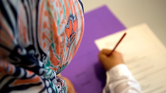 Schulmädchen von hinten. Es trägt ein Kopftuch. Schulmädchen von hinten. Es trägt ein Kopftuch.