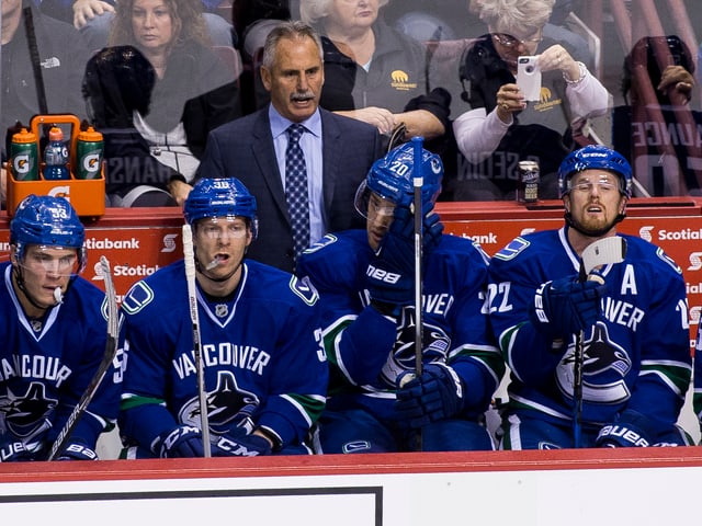 Willie Desjardins (Mitte hinten) an der Bande der Vancouver Canucks Willie Desjardins (Mitte hinten) an der Bande der Vancouver Canucks