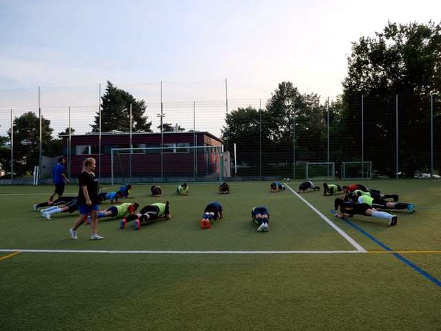 Fussballspieler machen die Brett-Übung Fussballspieler machen die Brett-Übung