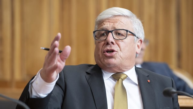 Politiker mit weissen Haaren und Brille am Rednerpult im Parlament. Politiker mit weissen Haaren und Brille am Rednerpult im Parlament.