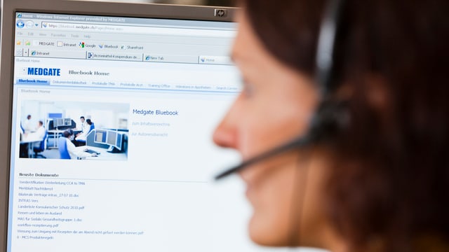 Eine Frau mit Headset an einem Bildschirm mit Medgate-Logo oben links. Eine Frau mit Headset an einem Bildschirm mit Medgate-Logo oben links.