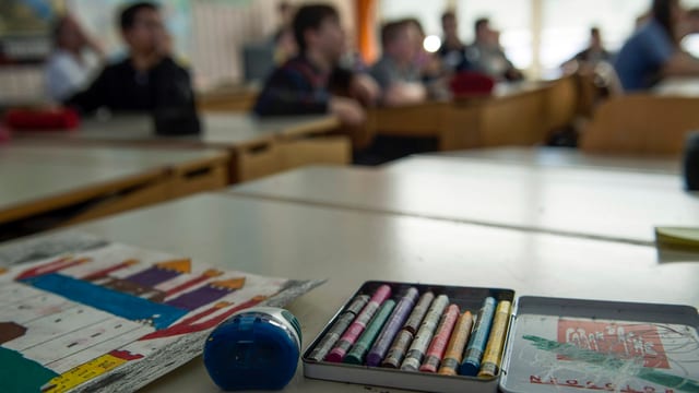 Malkasten, im Hintergrund Kinder in einem Schulzimmer Malkasten, im Hintergrund Kinder in einem Schulzimmer