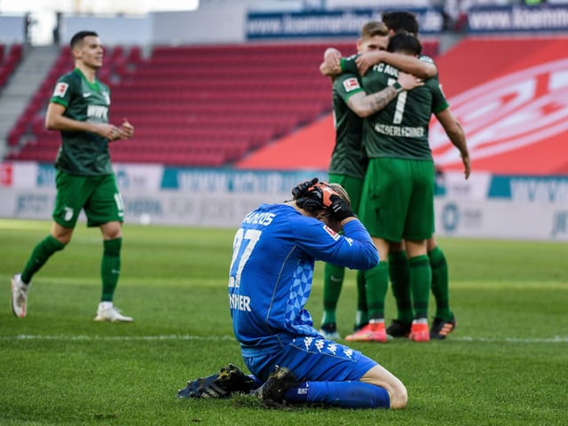 Während die Augsburg-Spieler über den einzigen Treffer der Partie jubeln, ist Mainz-Torhüter Robin Zentner bedient. Das Tor erzielte André Hahn, der in der 25. Minute von einem kapitalen Fehlpass von Zentner profitierte. Mit einem Sieg hätte Mainz den Abstiegsplatz verlassen können.