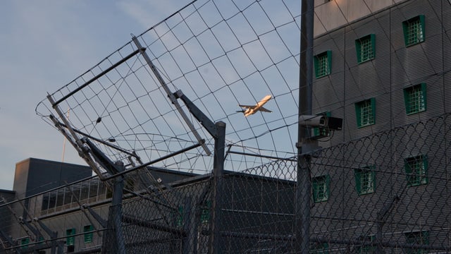 Ein Flugzeug über den Dächern des Gefängnisses am Flughafen Zürich. Ein Flugzeug über den Dächern des Gefängnisses am Flughafen Zürich.