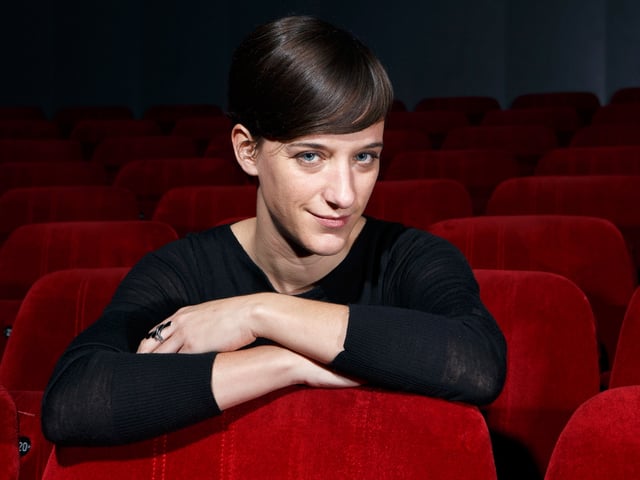 Eine junge Frau allein in einem Kinosaal. Eine junge Frau allein in einem Kinosaal.
