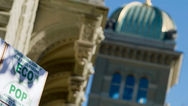 Bundeshauskuppel im Hintergrund, am Rand eine Kartonschachtel, die mit ECOPOP angeschrieben ist. Bundeshauskuppel im Hintergrund, am Rand eine Kartonschachtel, die mit ECOPOP angeschrieben ist.