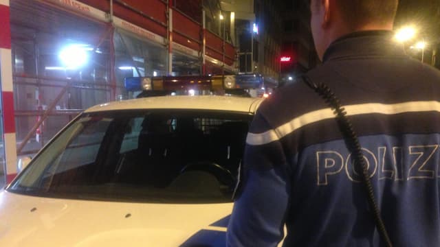 Ein Polizist steht vor einem Polizeiauto Ein Polizist steht vor einem Polizeiauto