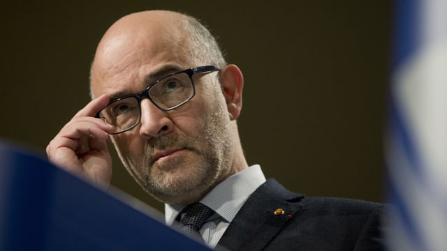 Mann, der eine Hand an der Brille hält. Mann, der eine Hand an der Brille hält.