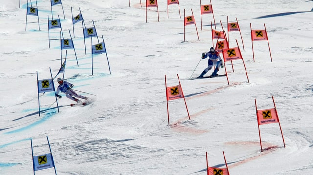 Zwei Athleten fahren im Parallel-Riesenslalom gemeinsam den Berg hinunter. 