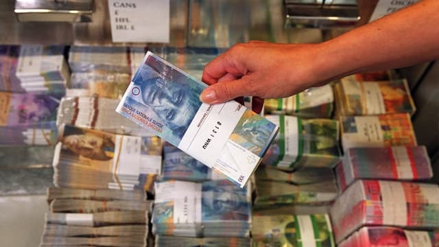 Eine Hand hält eine Hunderternote. Eine Hand hält eine Hunderternote.