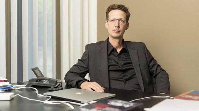 Politologe Michael Hermann sitzt an seinem Pult. Politologe Michael Hermann sitzt an seinem Pult.