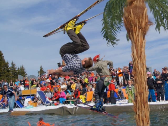 Skifahrer springen ins Wasser.