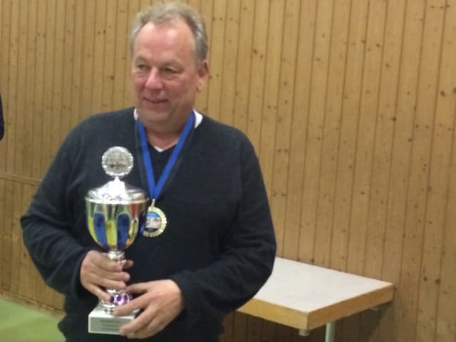 Ein Mann hält ein Pokal