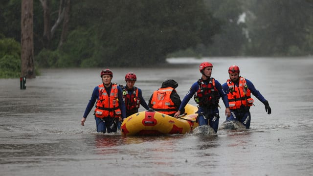 Menschen mit Schwimmweste und Schlauchboot Menschen mit Schwimmweste und Schlauchboot