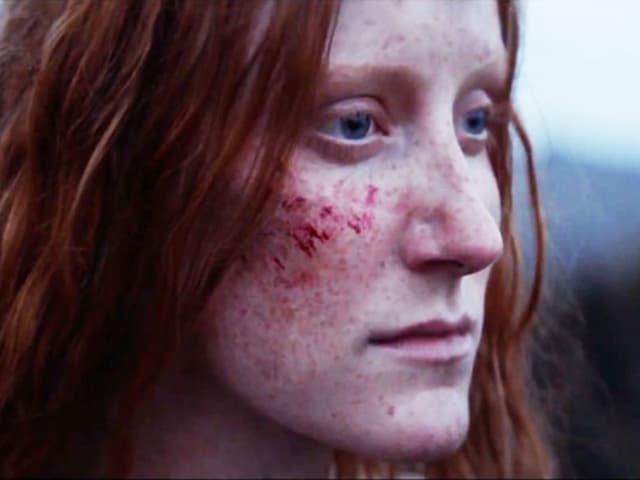 Ein Porträt einer Frau mit roten Haaren. Sie hat einen Kratzer im Gesicht. Ein Porträt einer Frau mit roten Haaren. Sie hat einen Kratzer im Gesicht.