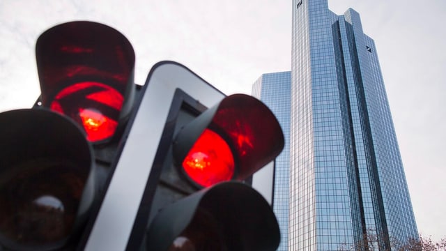 Eine rote Ampel vor dem Hauptsitz der Deutschen Bank. Eine rote Ampel vor dem Hauptsitz der Deutschen Bank.