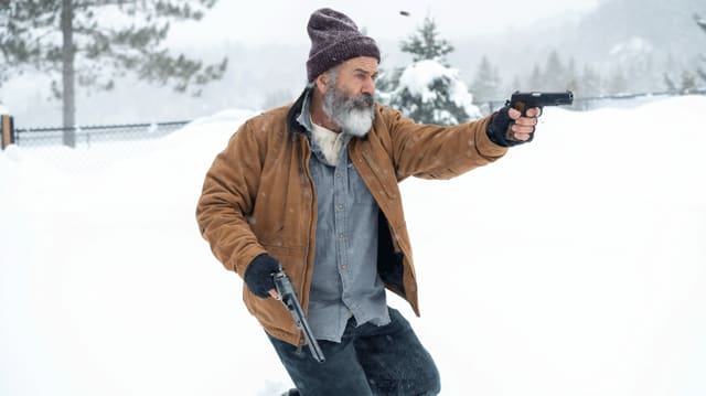 Ein Mann mit weissem Bart und Mütze rennt durch eine Schneelandschaft und schiesst mit zwei Pistolen. Ein Mann mit weissem Bart und Mütze rennt durch eine Schneelandschaft und schiesst mit zwei Pistolen.