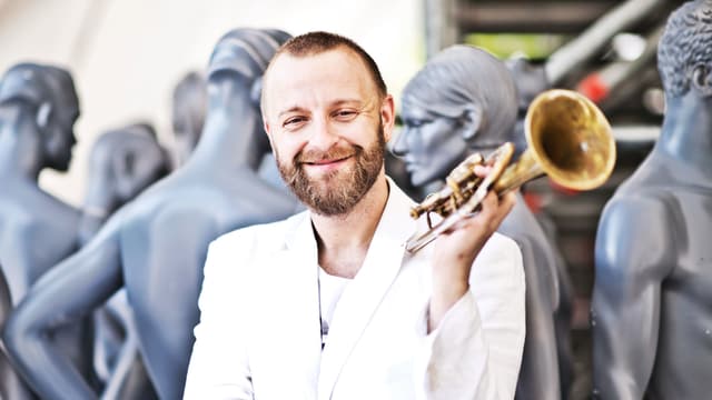 Mann vor Schaufensterpuppen mit Trompete. Mann vor Schaufensterpuppen mit Trompete.