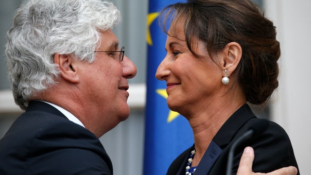 Philippe Martin, der abtretende Energieminister, lacht und umarmt Ségolène Royal. Philippe Martin, der abtretende Energieminister, lacht und umarmt Ségolène Royal.