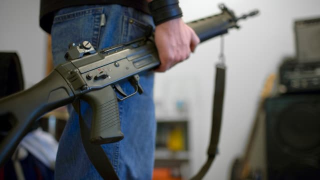 Ein Mann hält ein Sturmgewehr Ein Mann hält ein Sturmgewehr