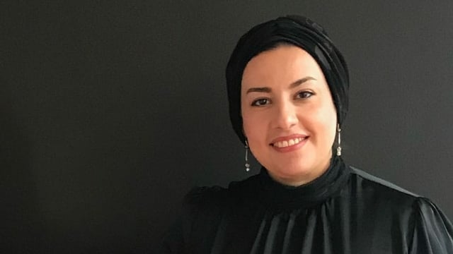 Eine Frau mit Kopftuch lächelt in die Kamera. Eine Frau mit Kopftuch lächelt in die Kamera.