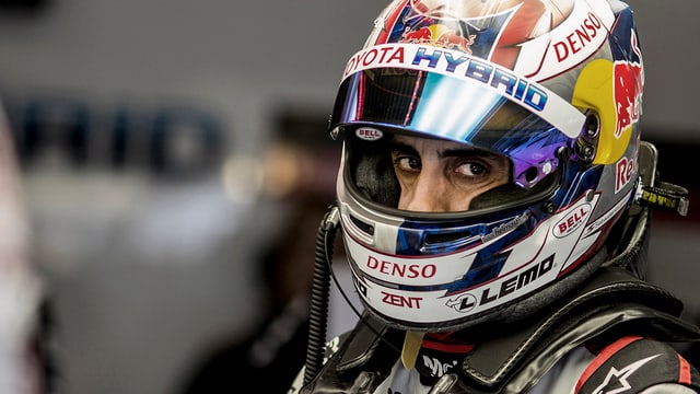 Sébastien Buemi blickt mit seinen dunklen Augen aus dem offenen Helmvisier hervor. Sébastien Buemi blickt mit seinen dunklen Augen aus dem offenen Helmvisier hervor.