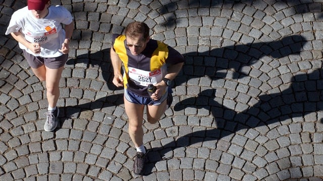Zwei Menschen joggen, von oben aufgenommen. Zwei Menschen joggen, von oben aufgenommen.