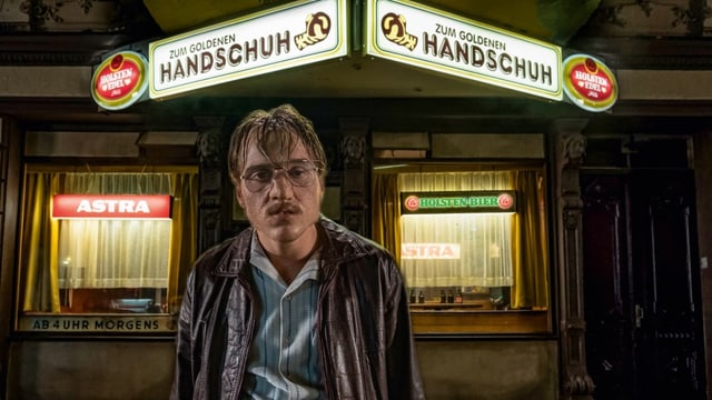 Ein Mann, der ziemlich fertig aussieht, steht vor einer Kneipe. Ein Mann, der ziemlich fertig aussieht, steht vor einer Kneipe.