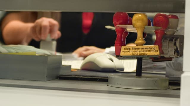 Eine Mitarbeiterin der Eidg. Steuerverwaltung stempelt ein Dokument: Die Finanzkontrolle untersucht diverse Vorwürfe gegen diese Behörde. Eine Mitarbeiterin der Eidg. Steuerverwaltung stempelt ein Dokument: Die Finanzkontrolle untersucht diverse Vorwürfe gegen diese Behörde.
