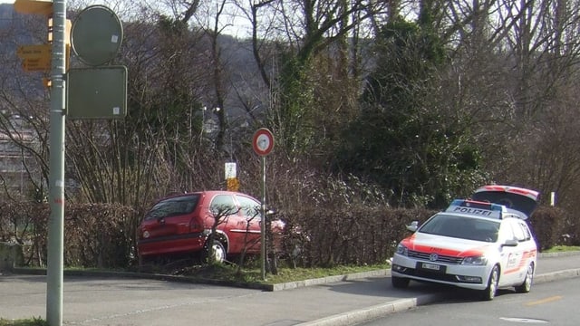 Das Unfallauto im Gebüsch, daneben ein Polizeiauto. Das Unfallauto im Gebüsch, daneben ein Polizeiauto.